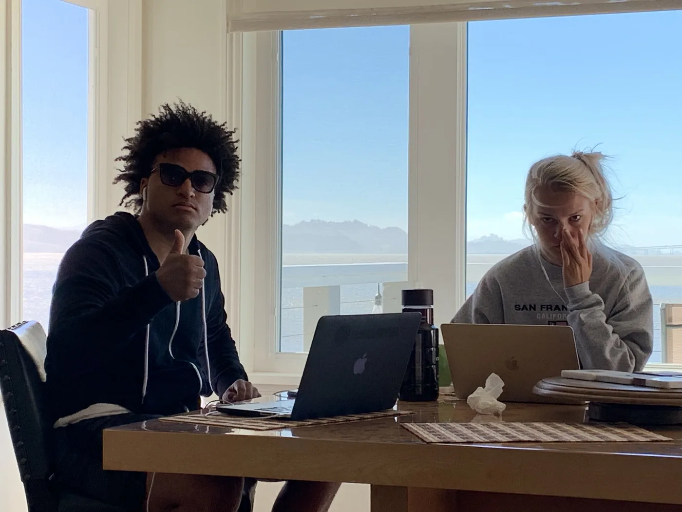 Torel and Liz on a business trip to speak in San Francisco. — Two laptops, the Bay outside the window, the work being done together.